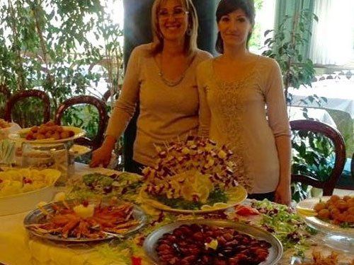 un buffet con i piatti serviti e due donne sorridente