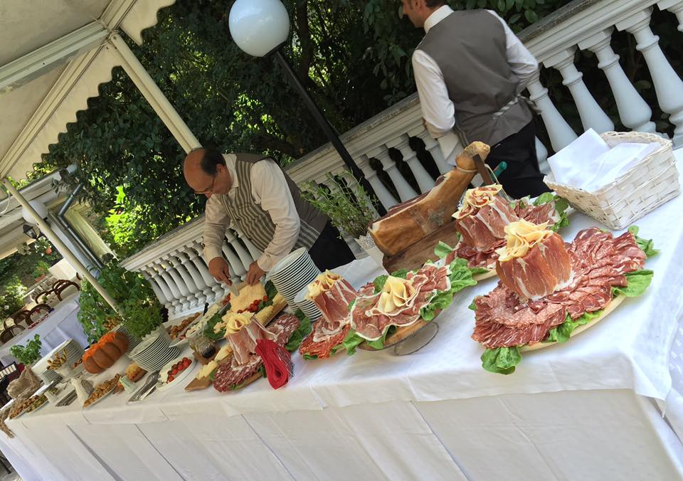 persona che taglia i salumi durante un buffet