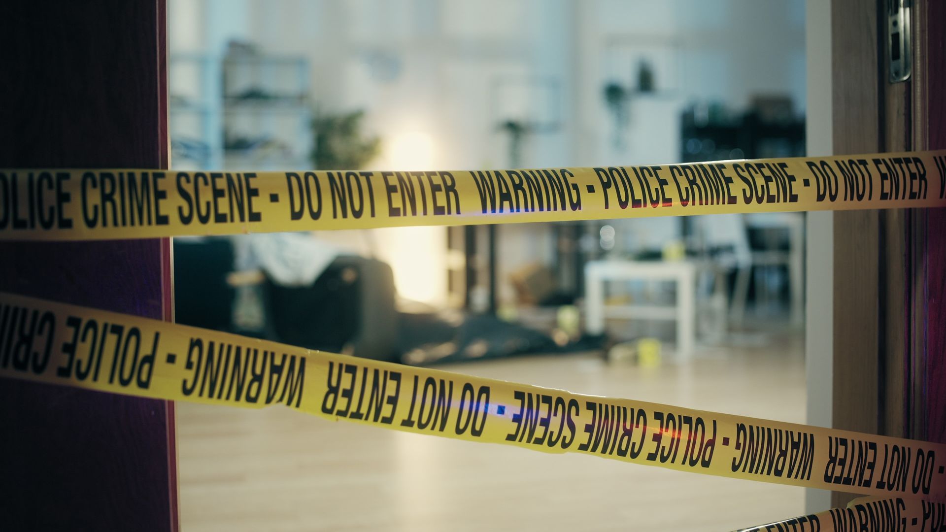 Yellow police tape across a doorway, warning