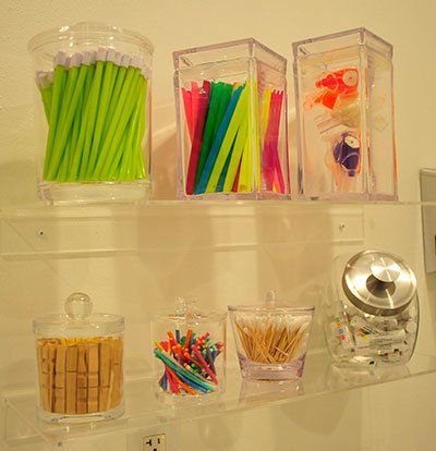 A shelf with a jar of toothpicks and a jar of straws