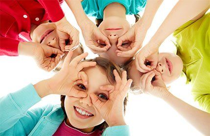 A group of children are making funny faces with their hands.