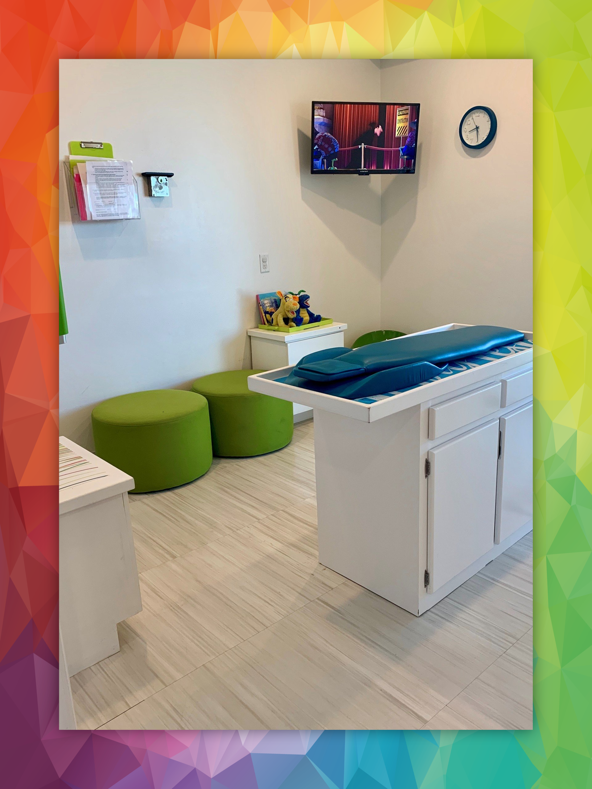 A doctor 's office with a table and a television on the wall.