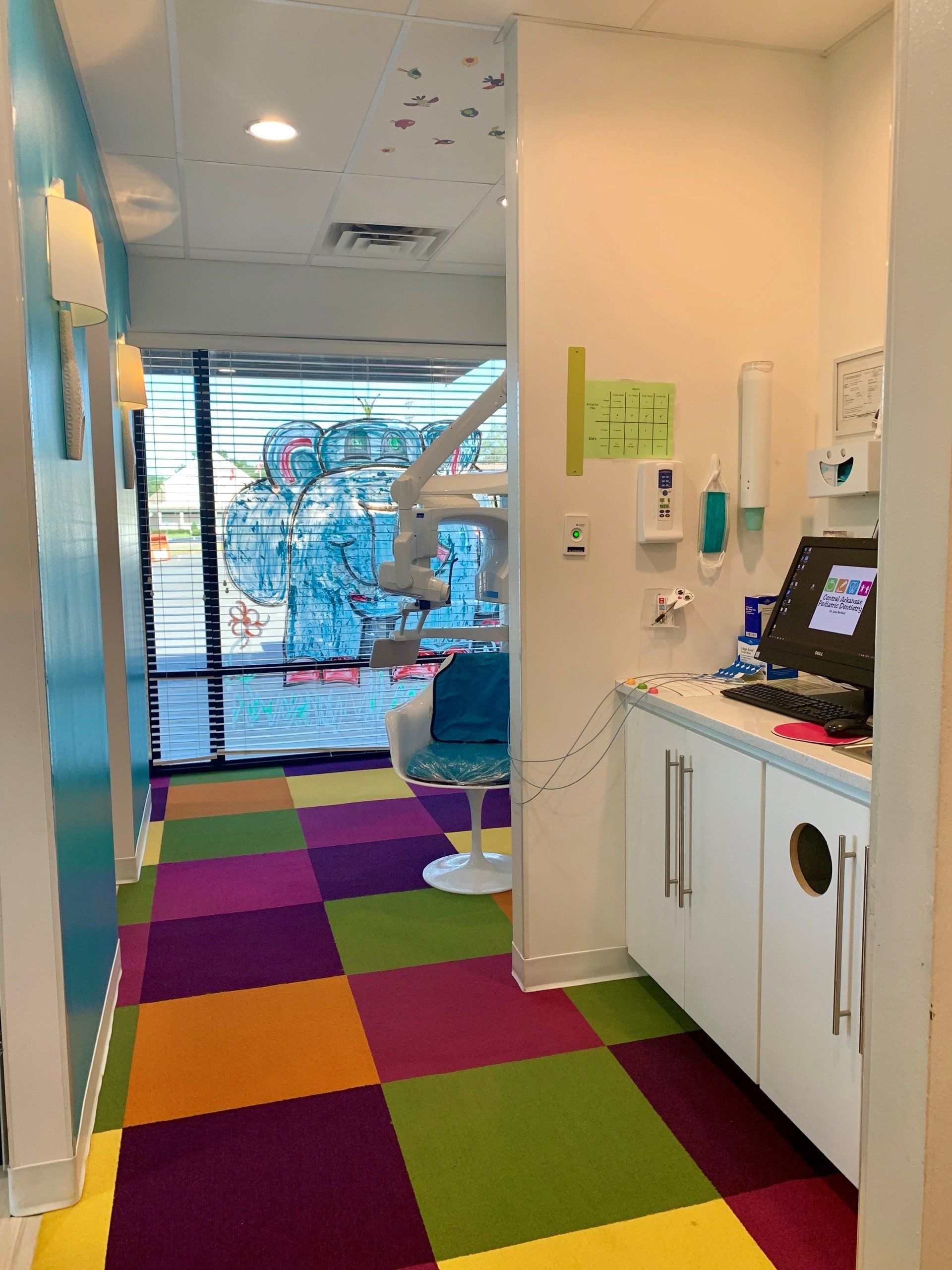 A hallway in a dental office with colorful tiles on the floor