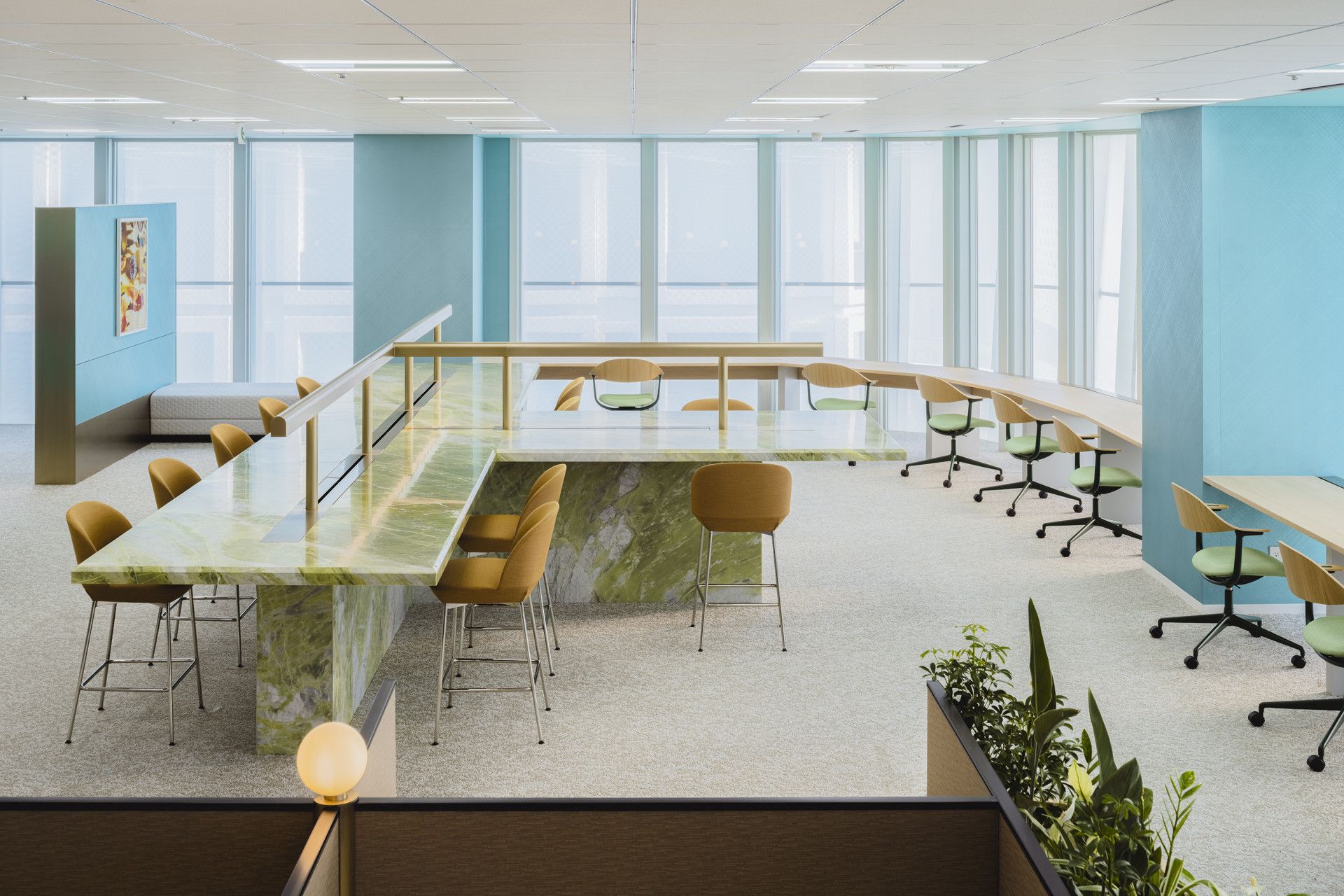 Modern office conference room with long tables, yellow chairs, and large windows.