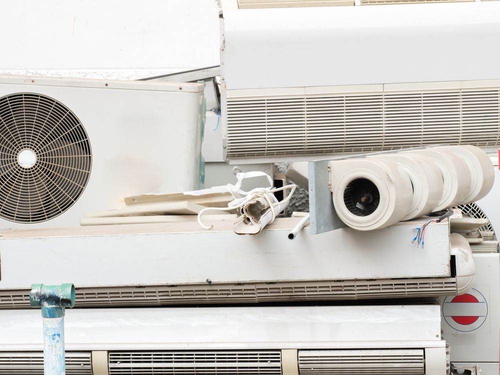 Pile of White Air Conditioning Units Some Damaged — Les Carman Cooling Solutions in Normanton, QLD