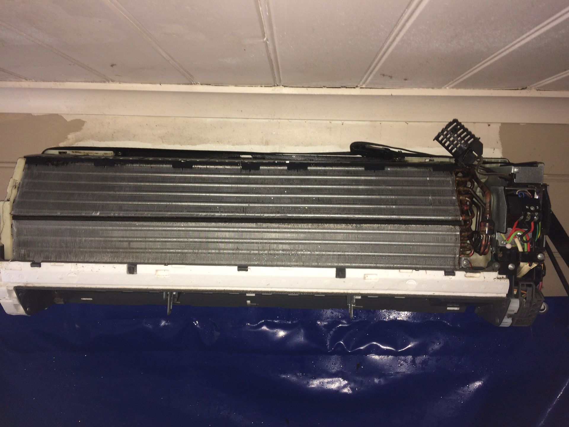 Man in Mask and Gloves Removing an Air Filter From a Ceiling Vent — Les Carman Cooling Solutions in El Arish, QLD