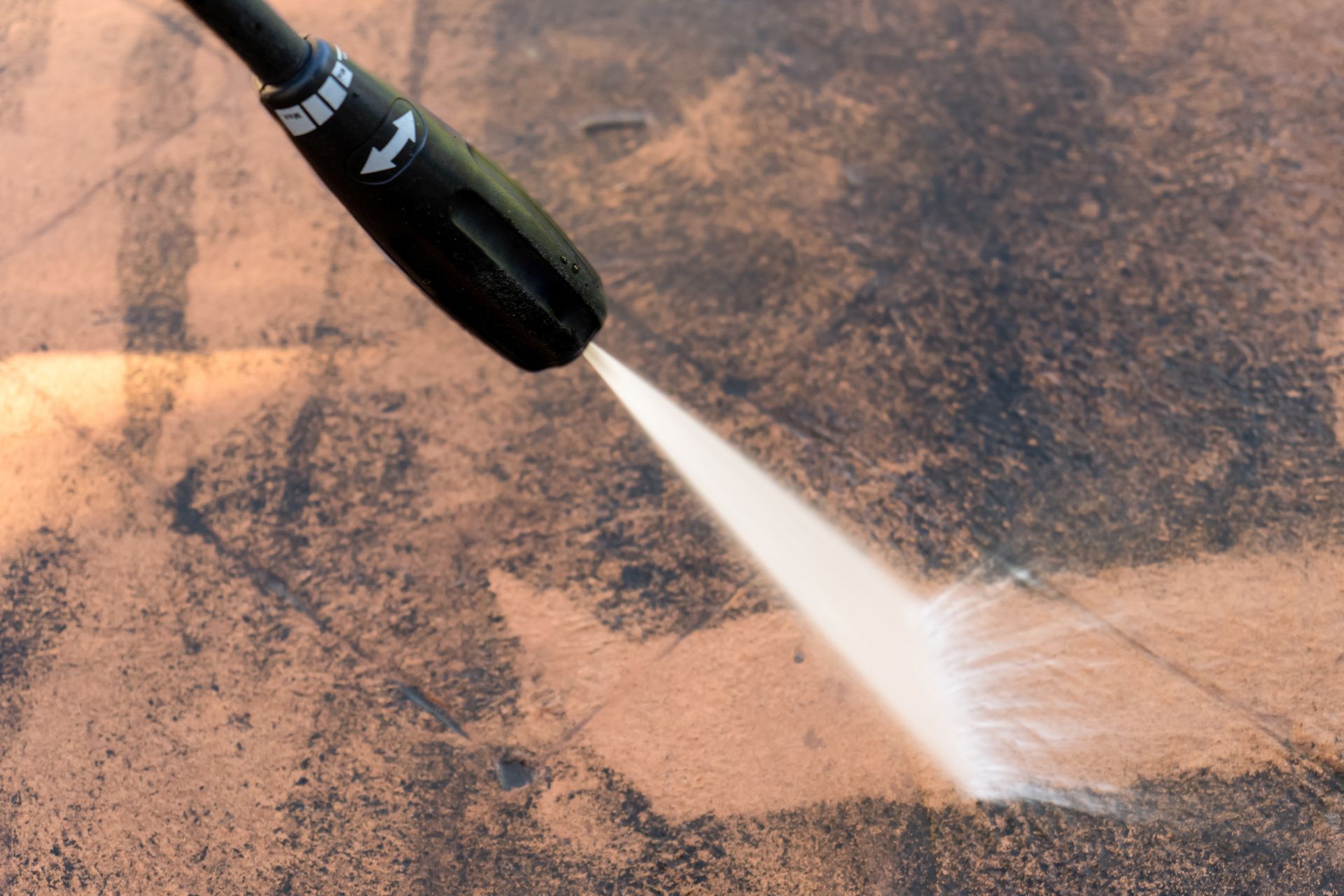 A high pressure washer is spraying water on a concrete surface. A high pressure washer is spraying water on a concrete surface.