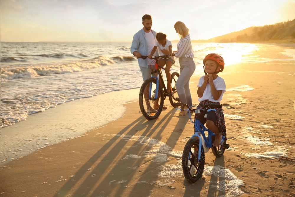 A Family is Riding Bikes on the Beach at Sunset — NH Legal In South Nowra, NSW