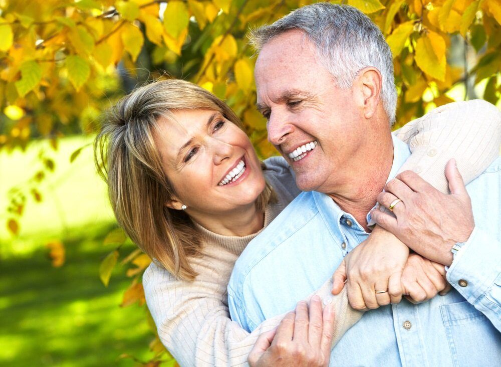 A Man and a Woman Are Hugging Each Other in a Park and Smiling — NH Legal In Shellharbour, NSW