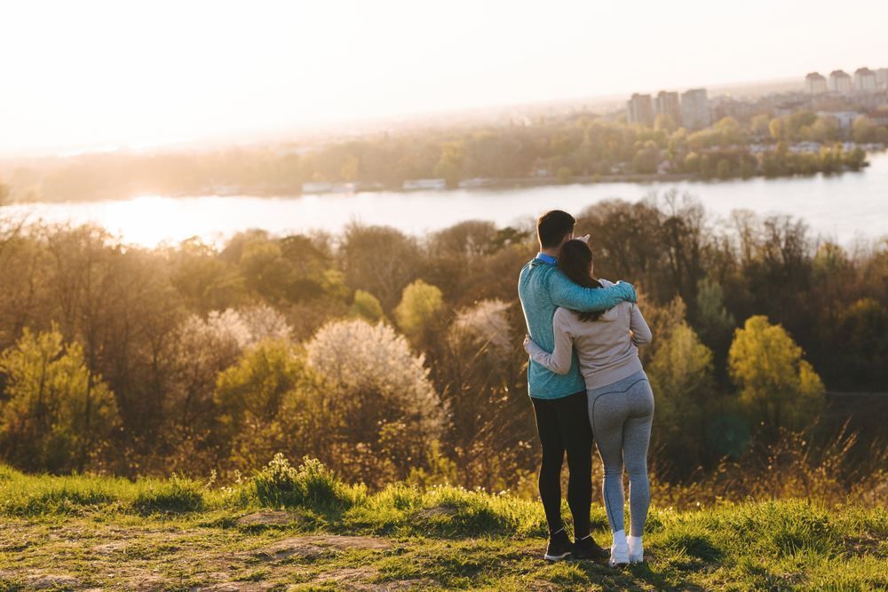 A Man and a Woman Are Standing on Top of a Hill Looking at a Lake — NH Legal In South Nowra, NSW