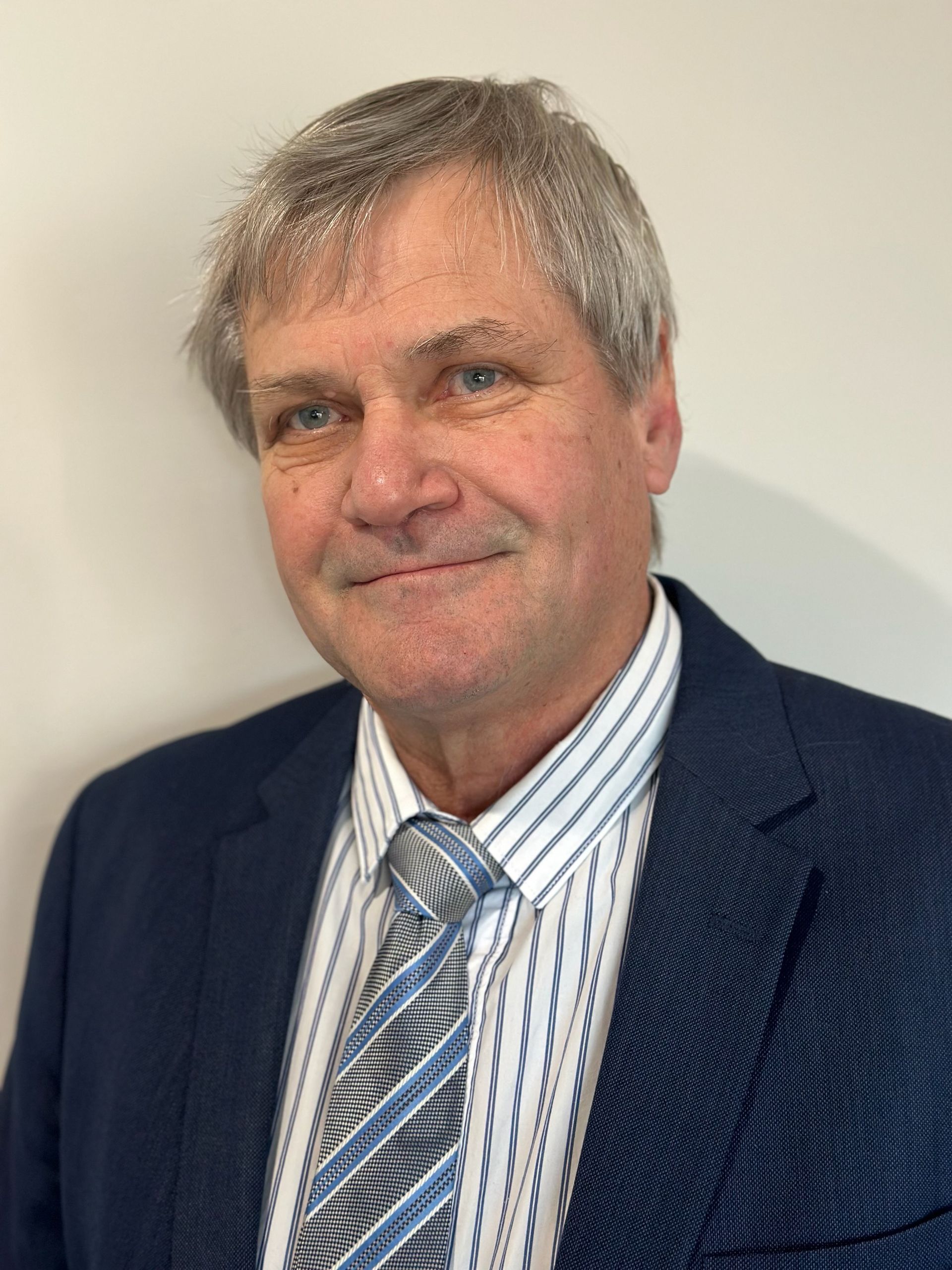 A man in a suit is smiling for a photo — NH Legal In South Nowra, NSW