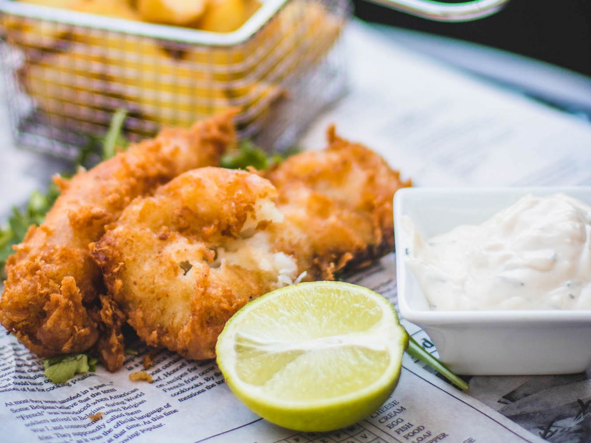 Gebratener Fisch mit Remoulade und einer Zitronenspalte.