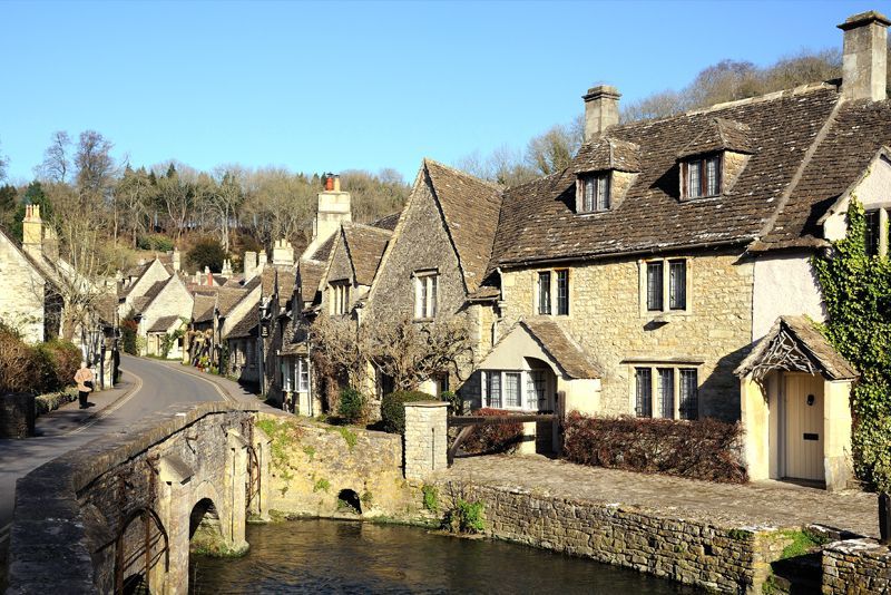 A small village with a bridge over a river and houses