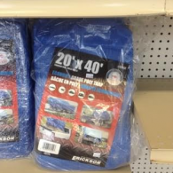 A packaged 20-foot by 40-foot blue poly tarp on a store shelf.