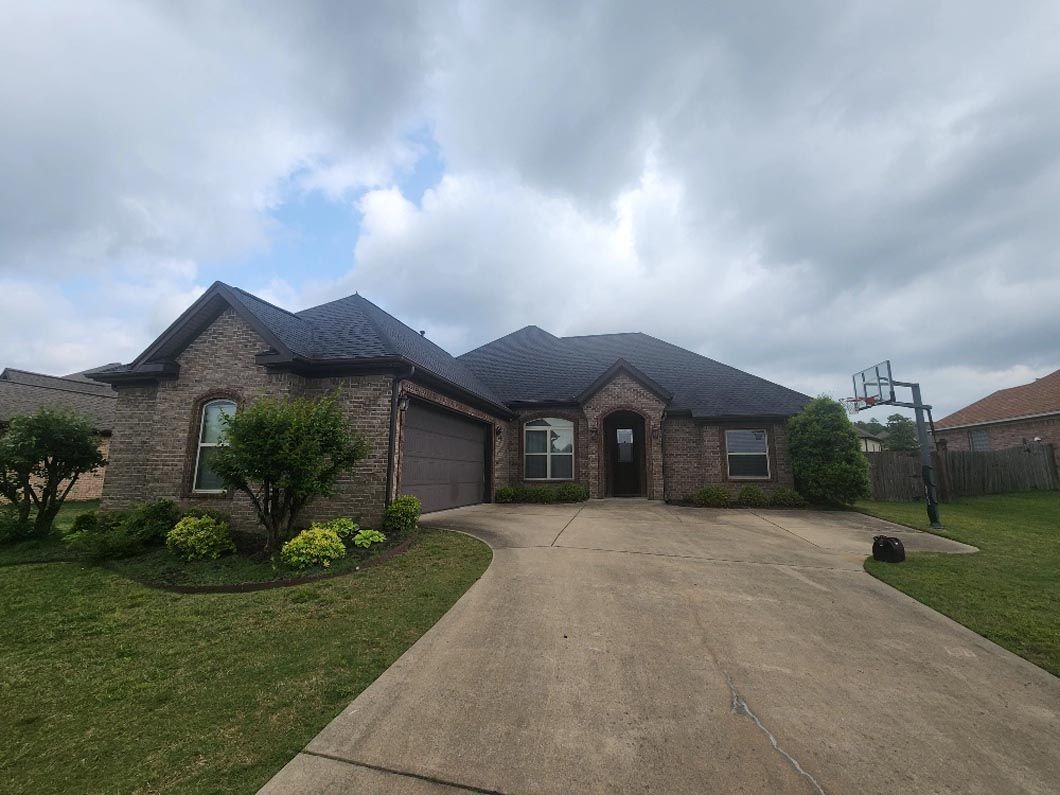 A large brick house with a driveway leading to it.