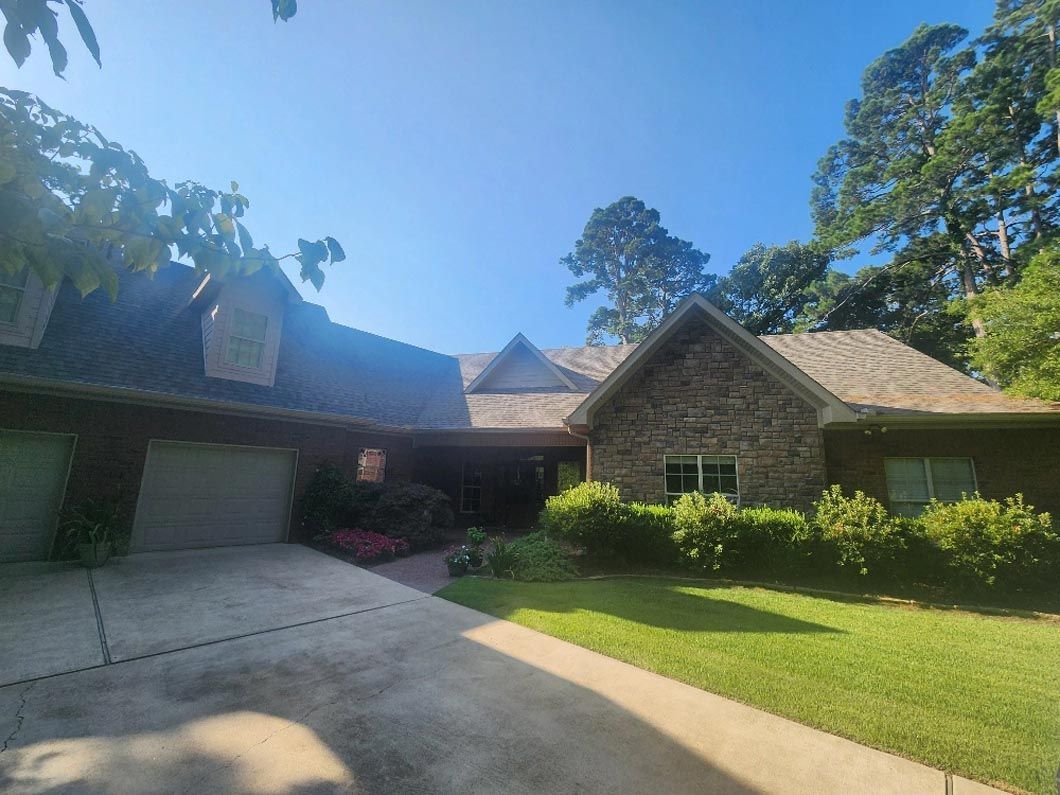 A large house with a lot of garages and a driveway in front of it.