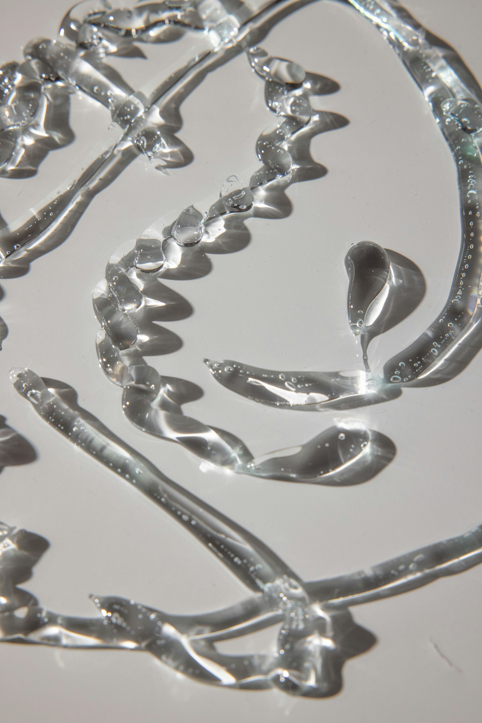 Un primer plano de un remolino de pintura plateada sobre una superficie blanca.