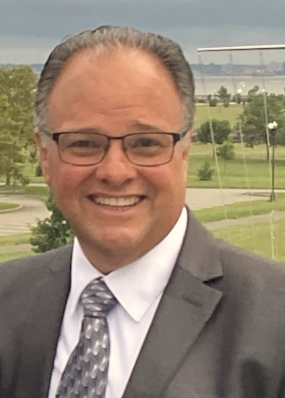 A man in a suit and tie is smiling for the camera.