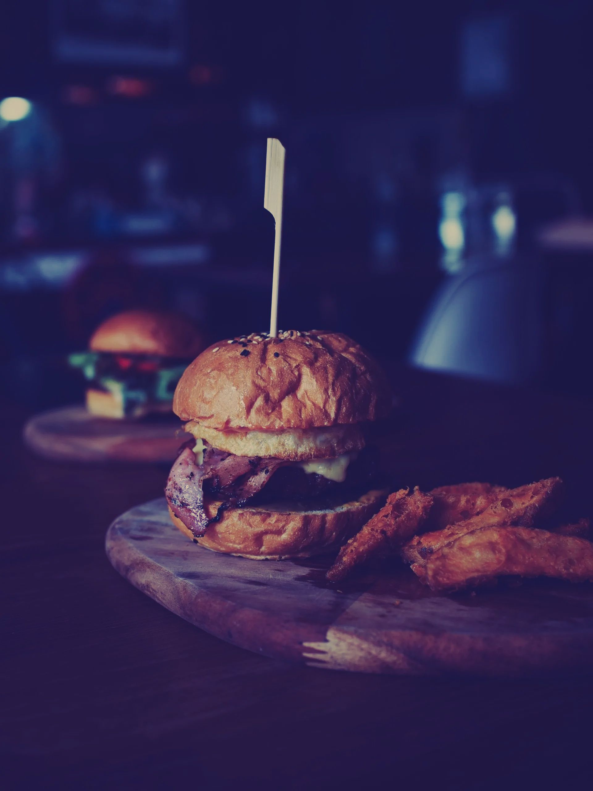 A hamburger and french fries on a wooden cutting board