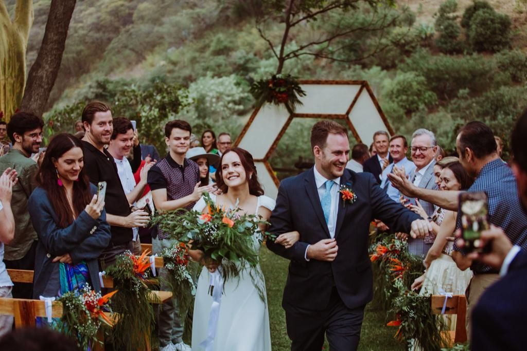 Una novia y un novio caminan hacia el altar en su boda.