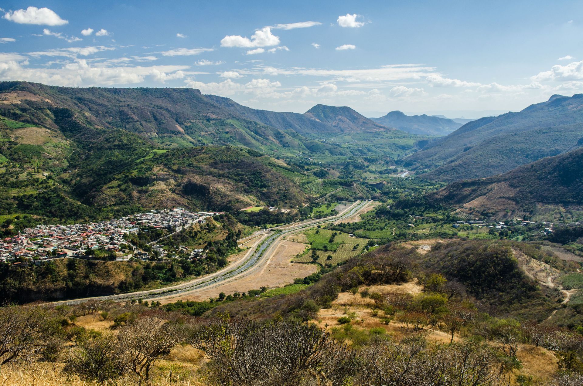 Una vista de un valle rodeado de montañas y árboles.
