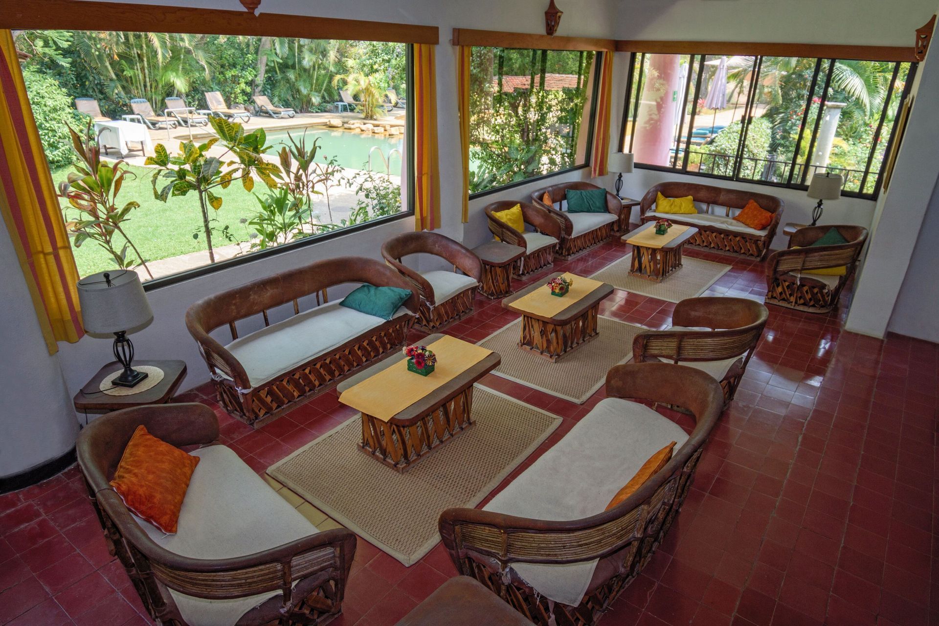 Una sala de estar con muchos muebles y una piscina al fondo.