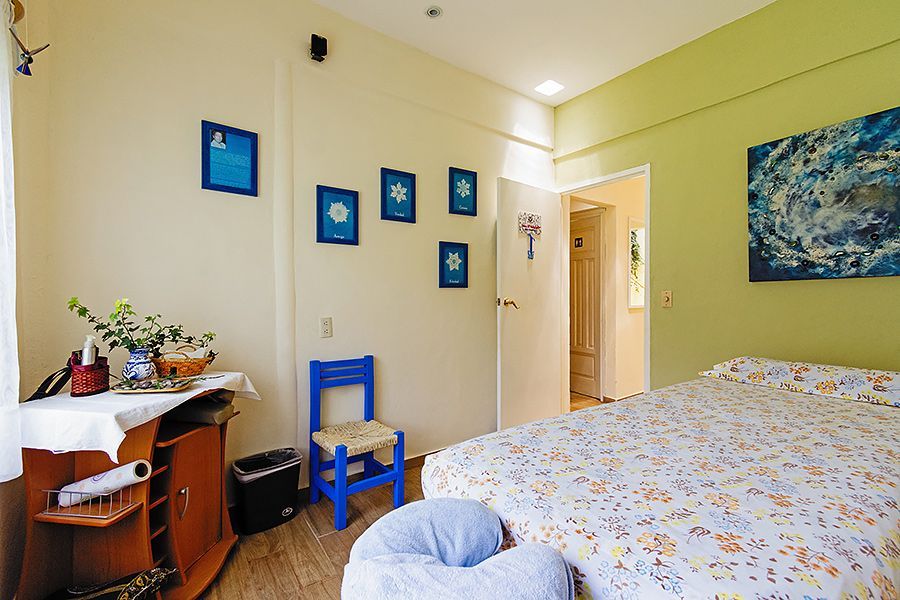 Un dormitorio con una cama grande y una silla azul.