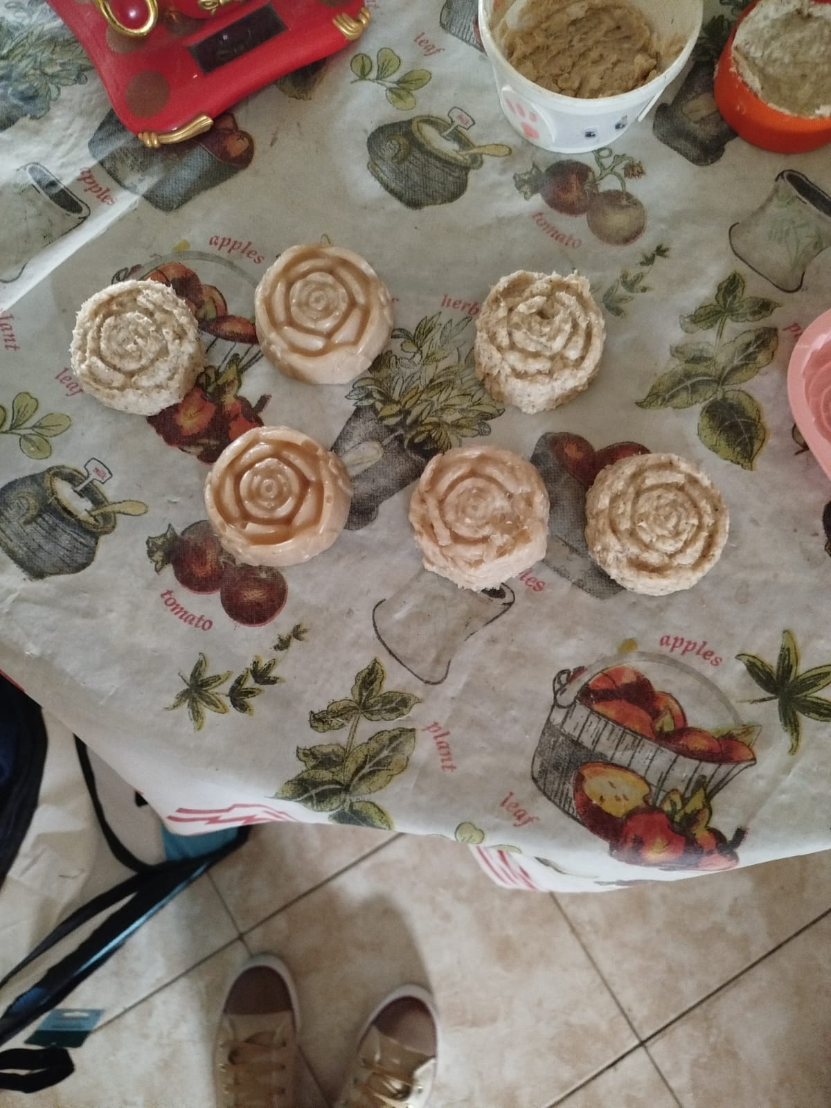 Siete productos horneados en forma de rosa sobre un mantel floral.