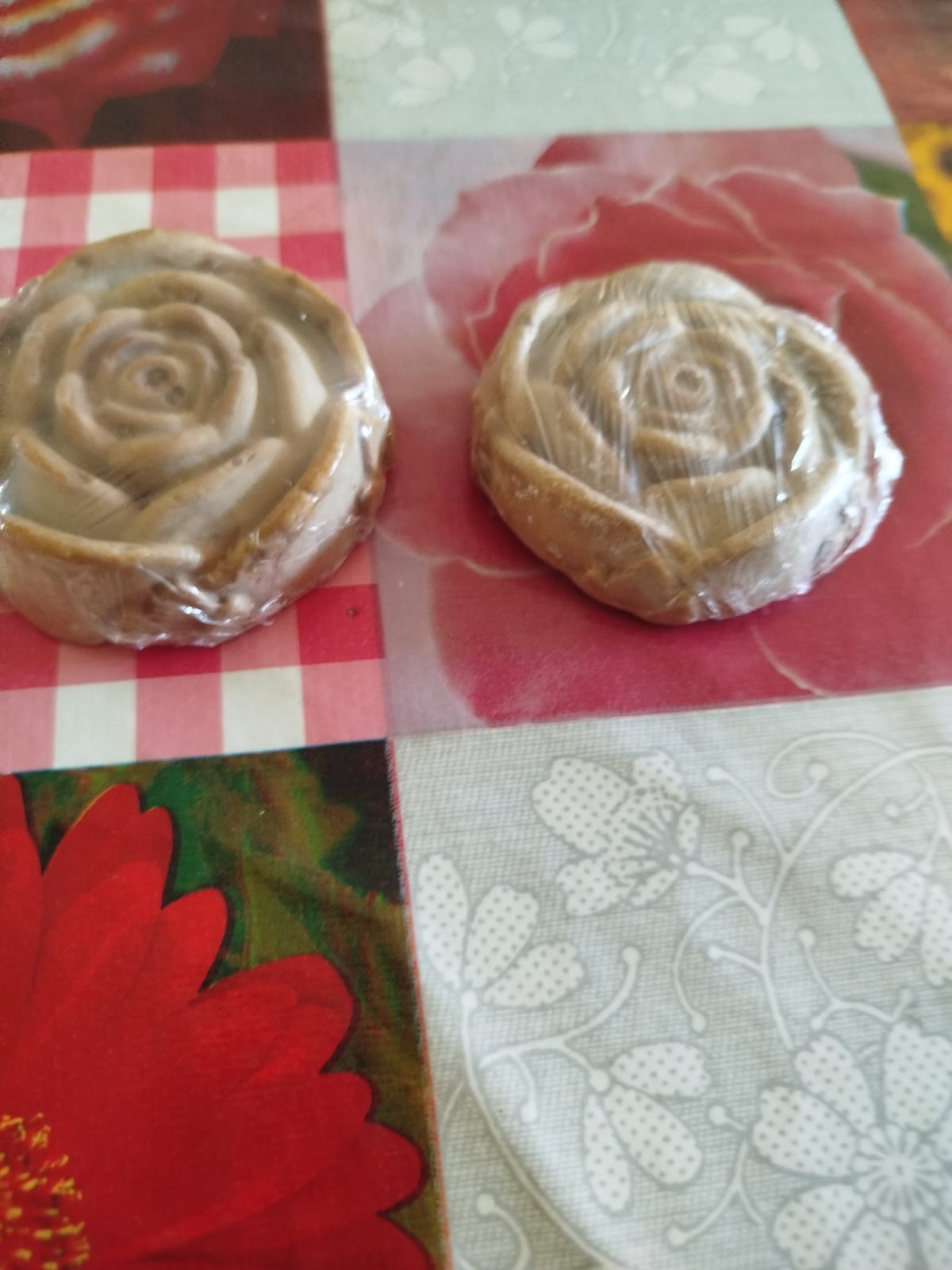 Dos artículos en forma de rosa, de color tostado, envueltos en plástico transparente