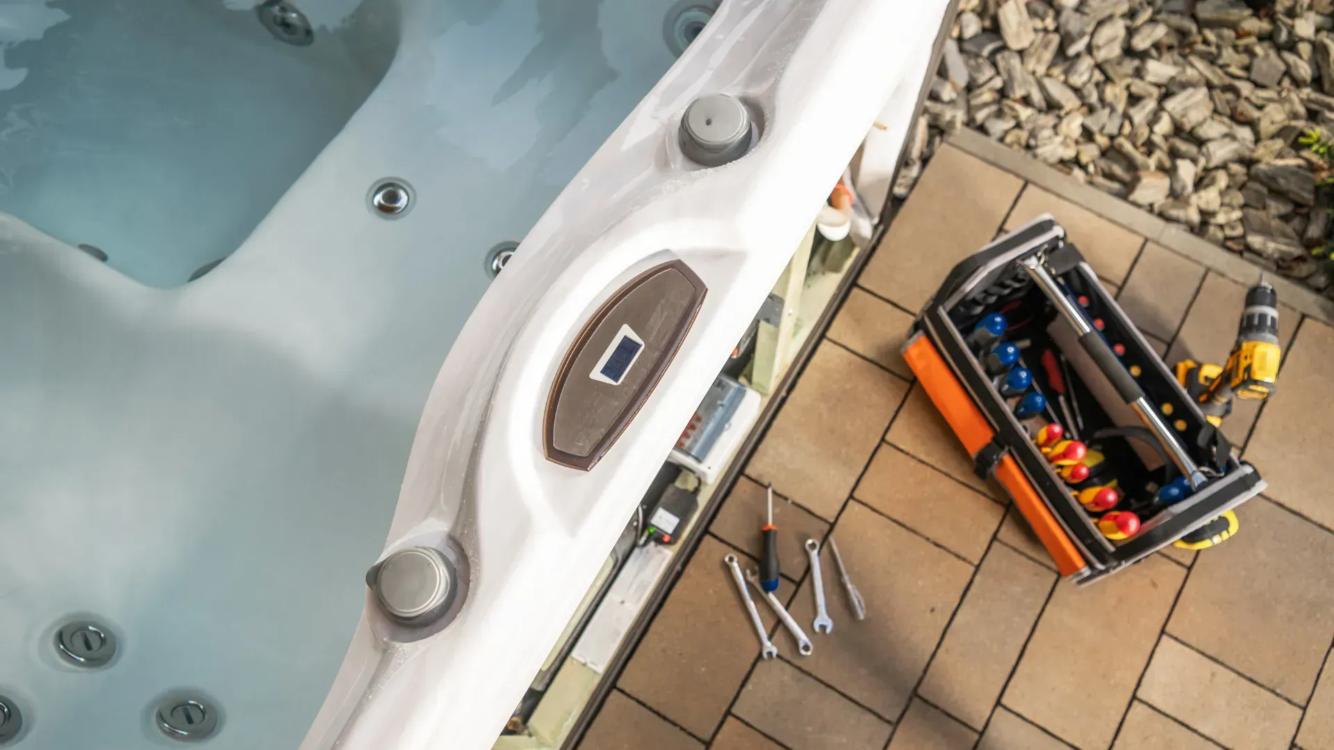 Hot tub being repaired; toolbox, tools, and drill next to it, outdoor setting.