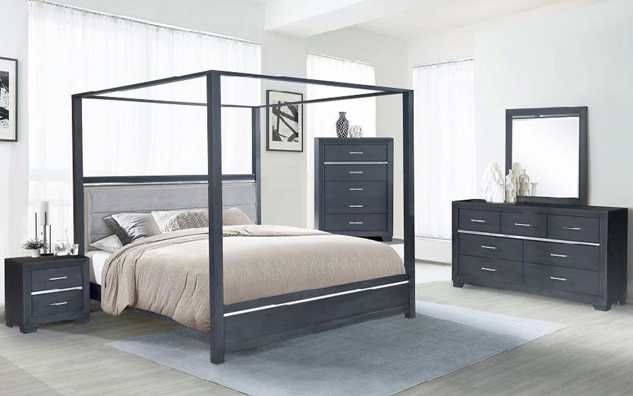 A bedroom with a canopy bed , dresser , nightstand and mirror.