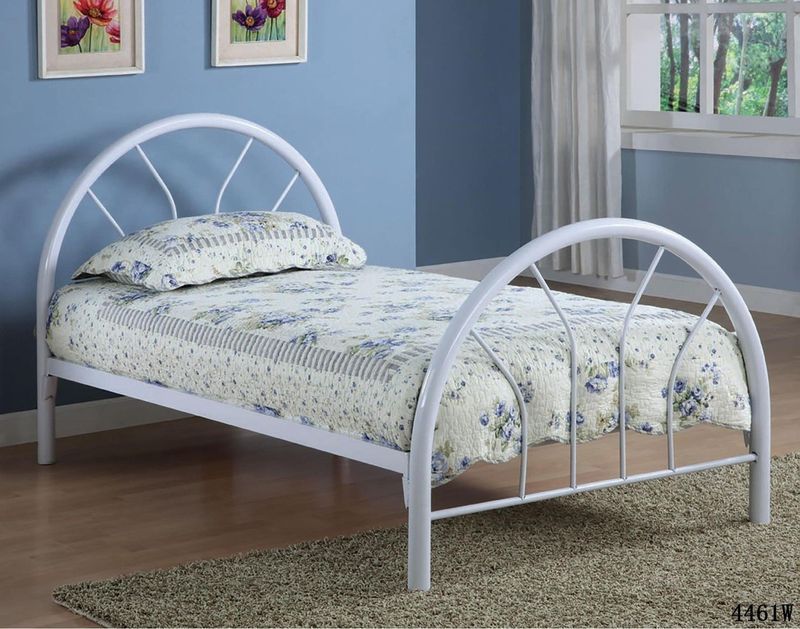 A white metal bed with a floral comforter in a bedroom