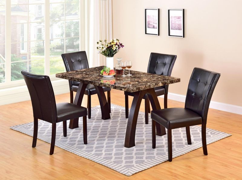 A marble dining table with four black chairs in a living room.
