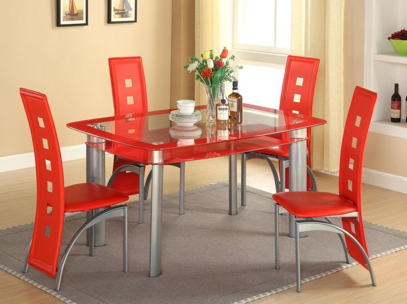 A glass dining table with red chairs in a living room
