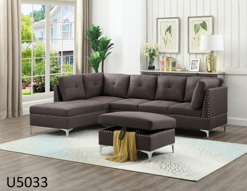 A living room with a sectional couch and ottoman.