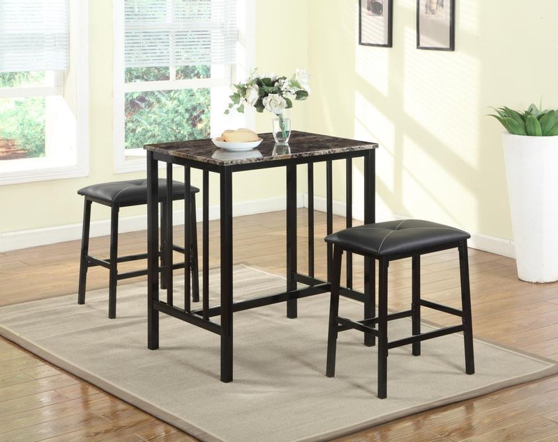 A table with two stools and a vase of flowers on it