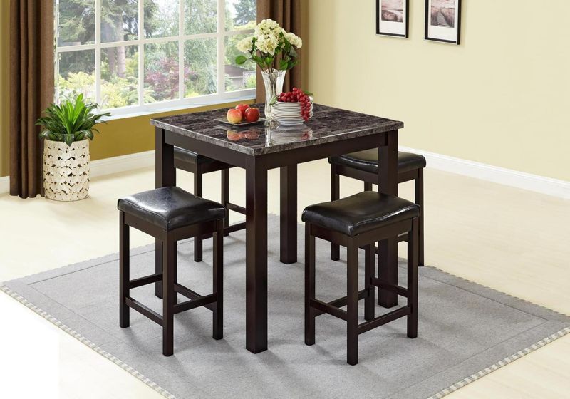 A dining room table with a marble top and four stools