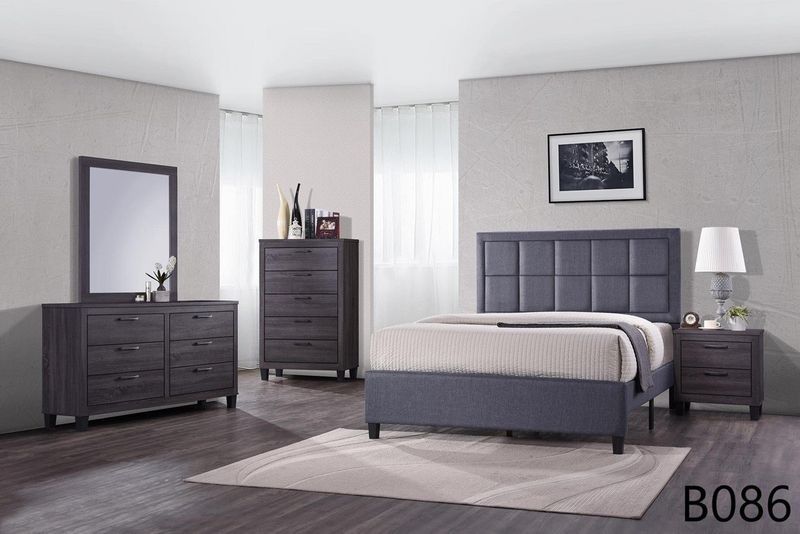 A bedroom with a bed , dresser , nightstand , mirror and rug.
