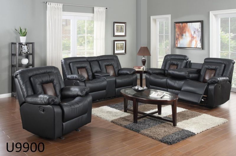 A living room with black leather furniture and a coffee table