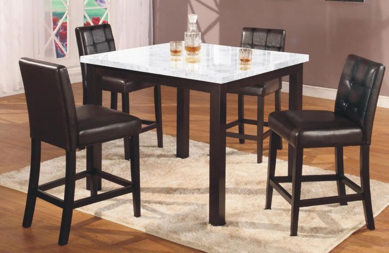 A dining room table with four chairs and a decanter of whiskey