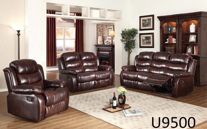 A living room with brown leather furniture and a bottle of wine on a table.