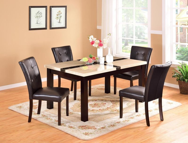 A dining room table with four chairs and a vase of flowers on it