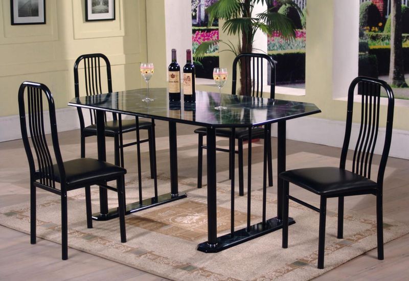 A dining room table with four chairs and two bottles of wine on it