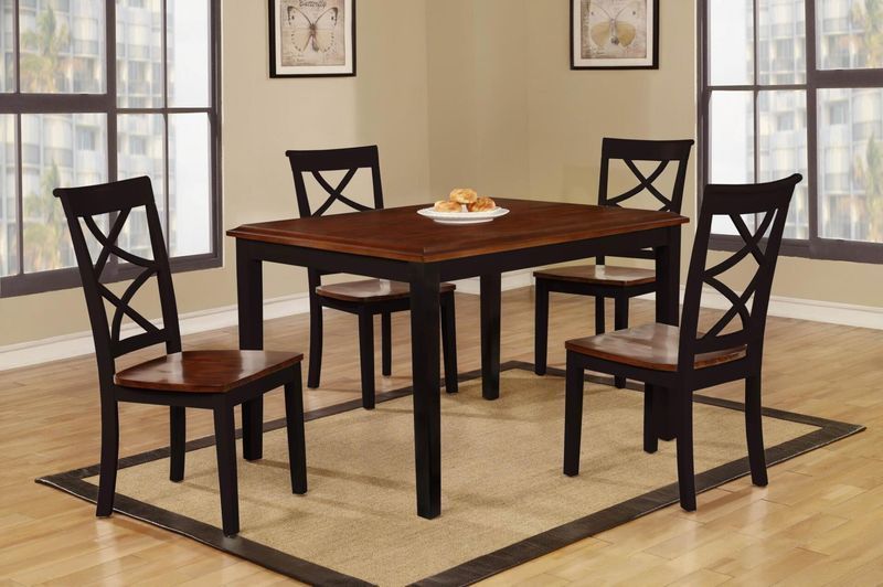 A dining room table with four chairs and a plate of food on it