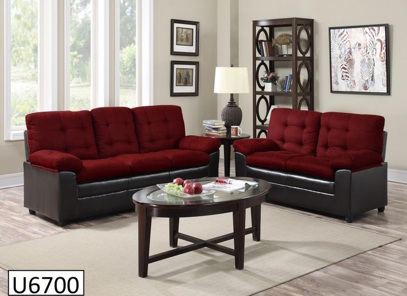 A living room with red and black furniture and a coffee table