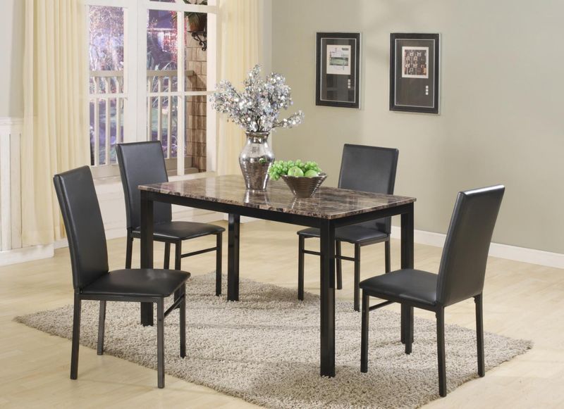 A marble dining table with four black chairs in a living room.