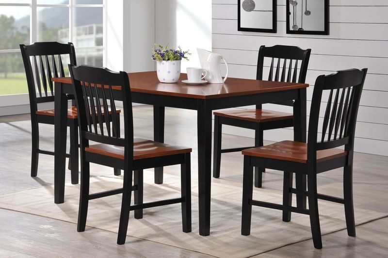 A dining room table with four chairs and a vase of flowers on it