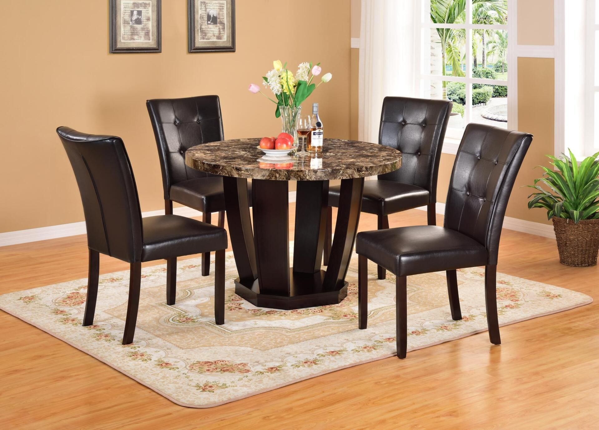 A marble dining table with four black chairs in a living room