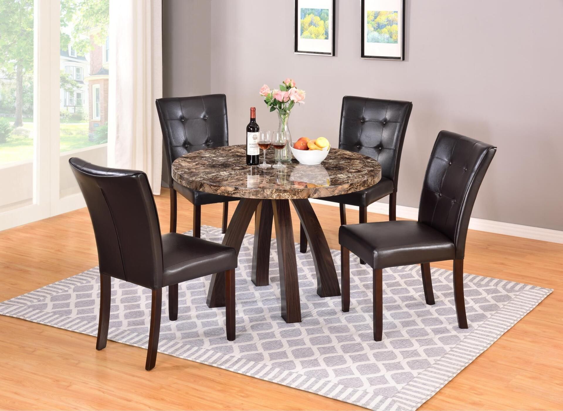A dining room table and chairs with a bottle of wine on it.