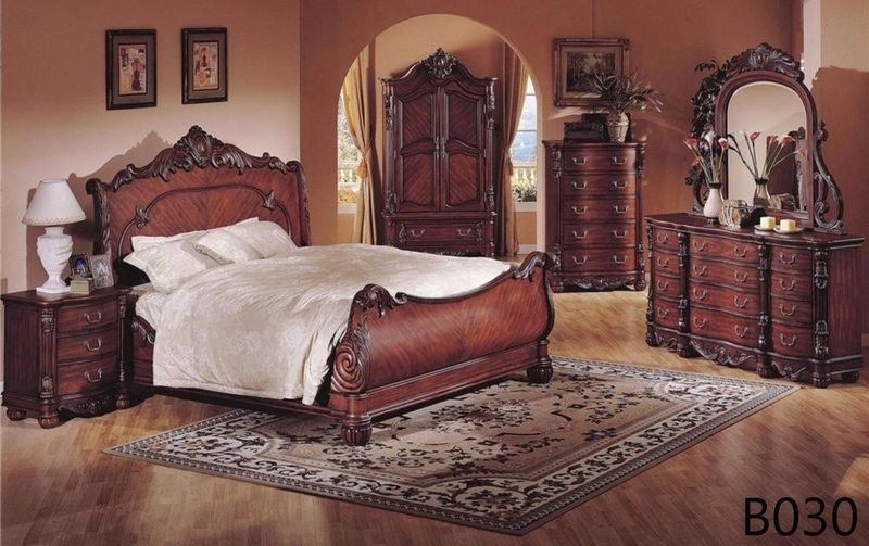 A bedroom with a sleigh bed dresser and nightstand